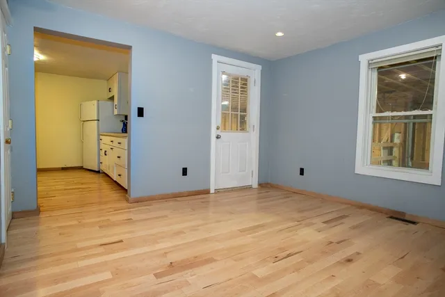 a view of empty room with wooden floor and window