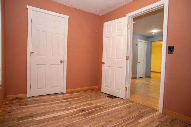 a view of an empty room with closet and a window