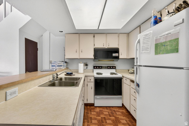 407 South Vasels Road, Unit 24 Brian Head, UT 84719 - Photo 10 of 63 Kitchen featuring white appliances, light countertops, cream cabinets, parquet floors, and a peninsula