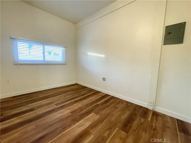 a view of a room with wooden floor and a window