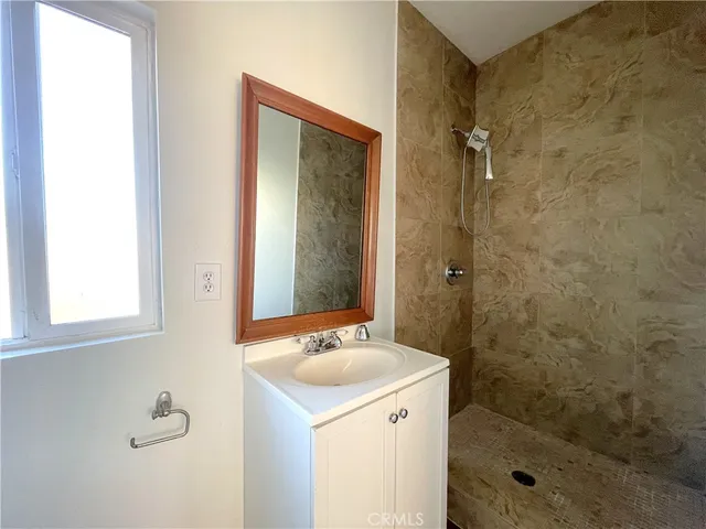 a bathroom with a shower sink and mirror