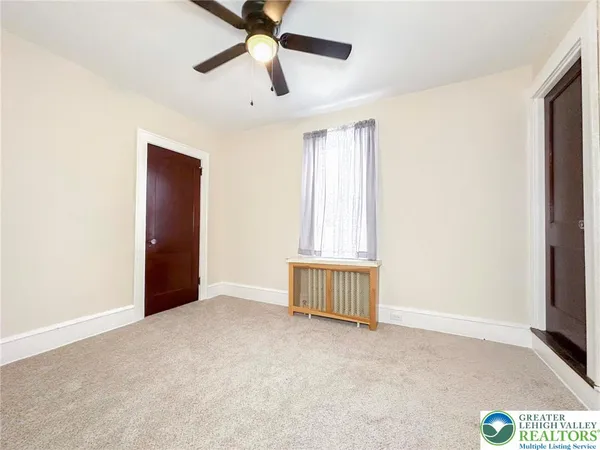 an empty room with windows and fan