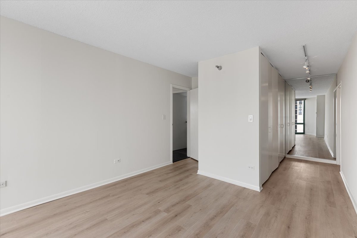 111 West Maple Street, Unit 3001 Chicago, IL 60610 - Photo 11 of 13 a view of a hallway with wooden floor