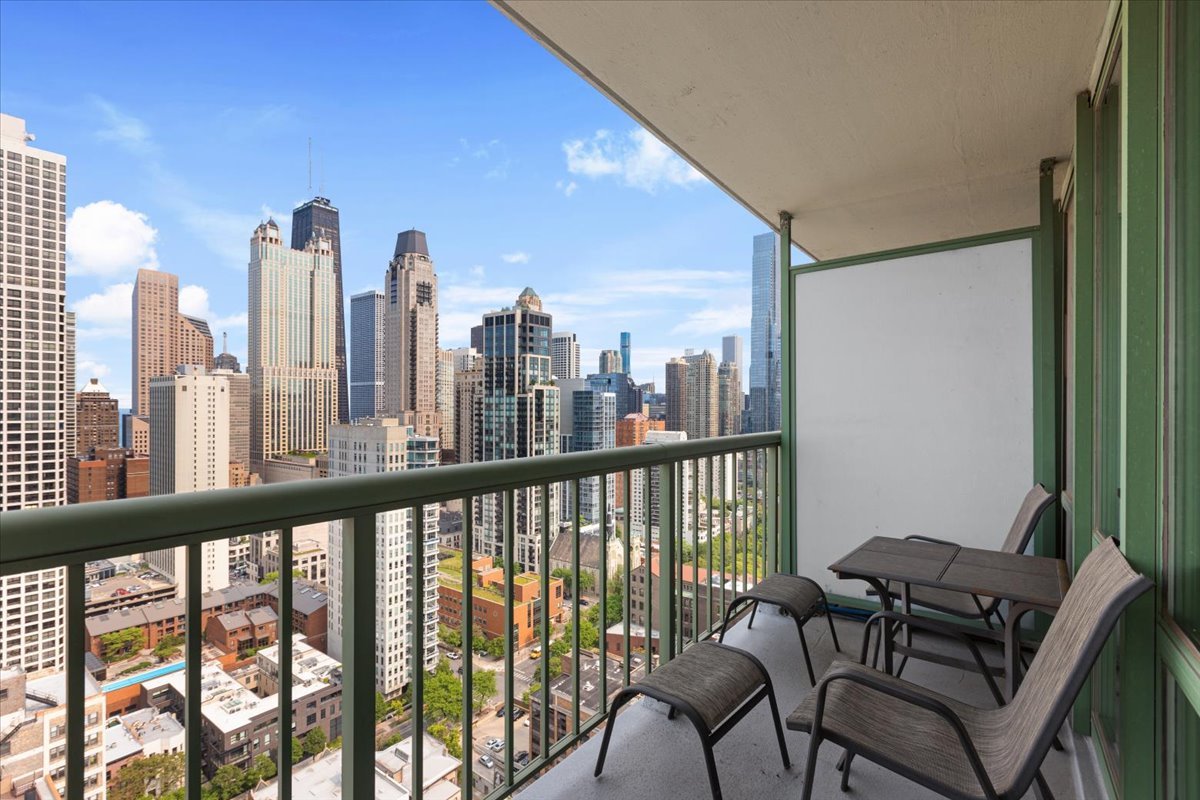111 West Maple Street, Unit 3001 Chicago, IL 60610 - Photo 6 of 13 a view of a city from a balcony with furniture