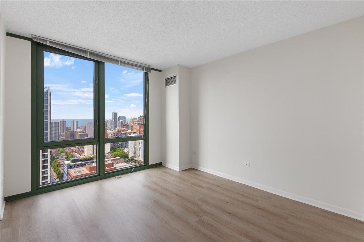 111 West Maple Street, Unit 3001 Chicago, IL 60610 - Photo 8 of 13 wooden floor in an empty room with a window