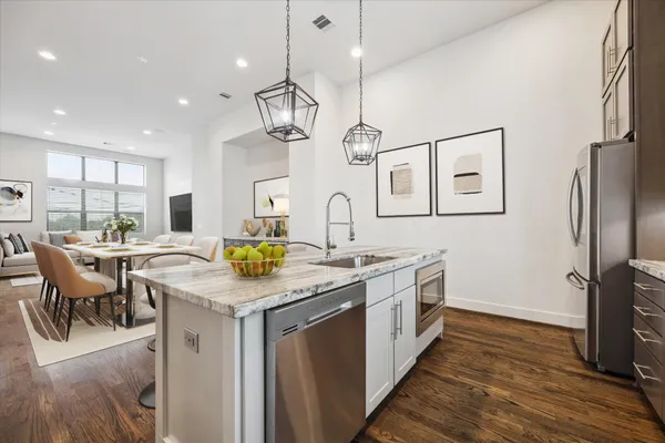 a kitchen with stainless steel appliances granite countertop a sink a stove and a refrigerator