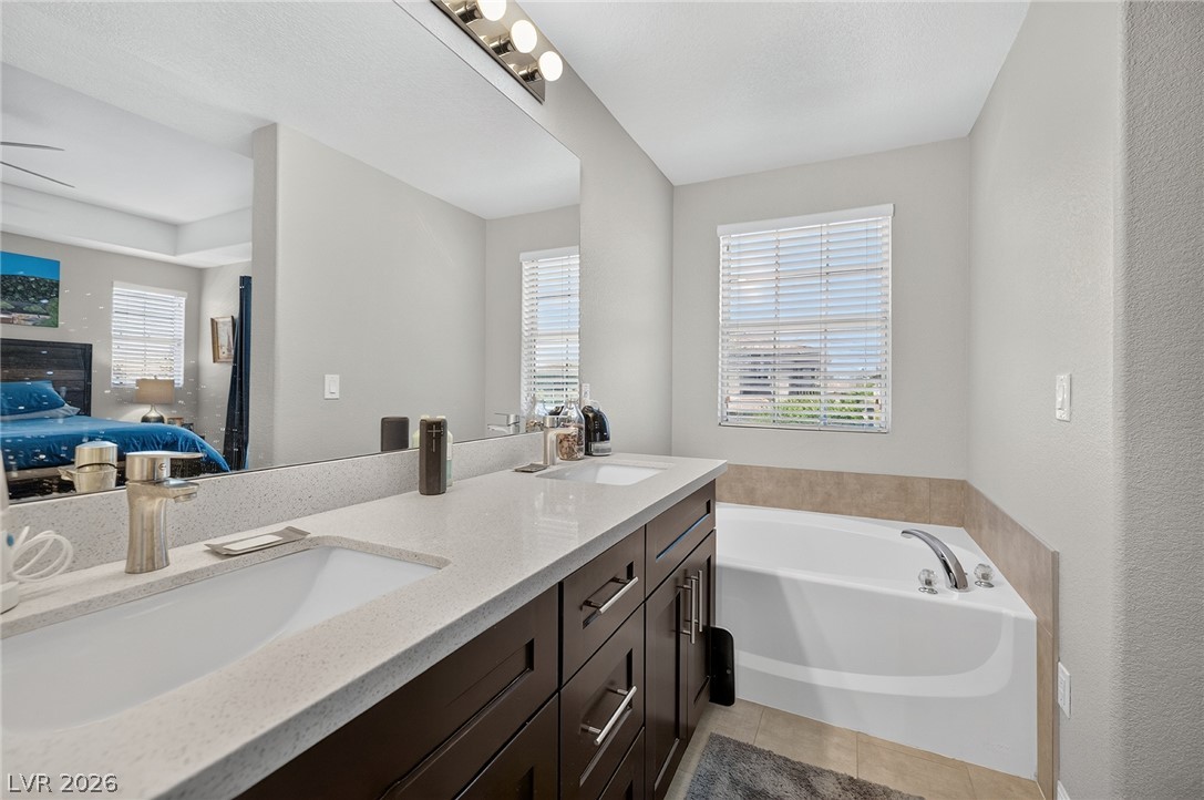226 Priority Point Street Henderson, NV 89012 - Photo 26 of 32 A spacious double vanity matches with a deep soaking tub nestled beneath the window.