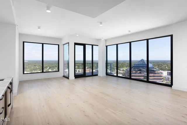 a view of an empty room with large windows and a balcony