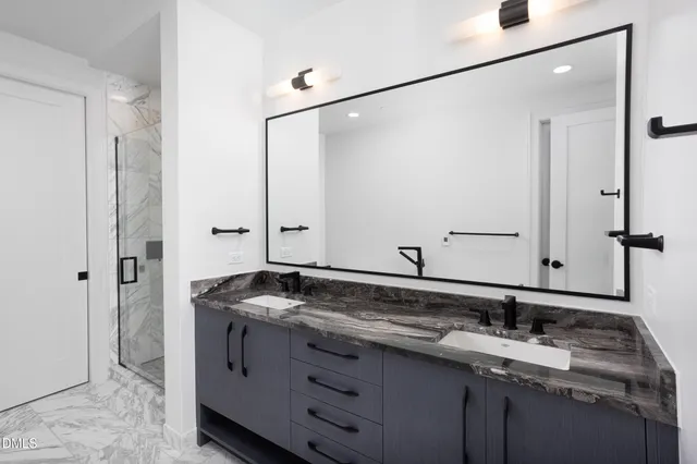 a bathroom with a granite countertop sink a toilet and a mirror