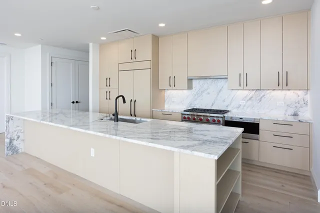 a kitchen with granite countertop a sink stove and cabinets