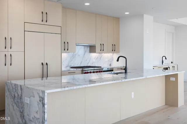 a kitchen with stainless steel appliances granite countertop a sink a refrigerator and a granite counter tops