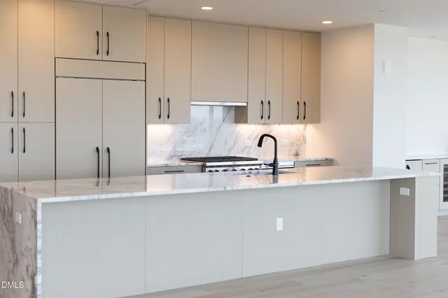 a kitchen with kitchen island a sink stainless steel appliances and cabinets