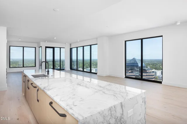 a large white kitchen with a large window and sink