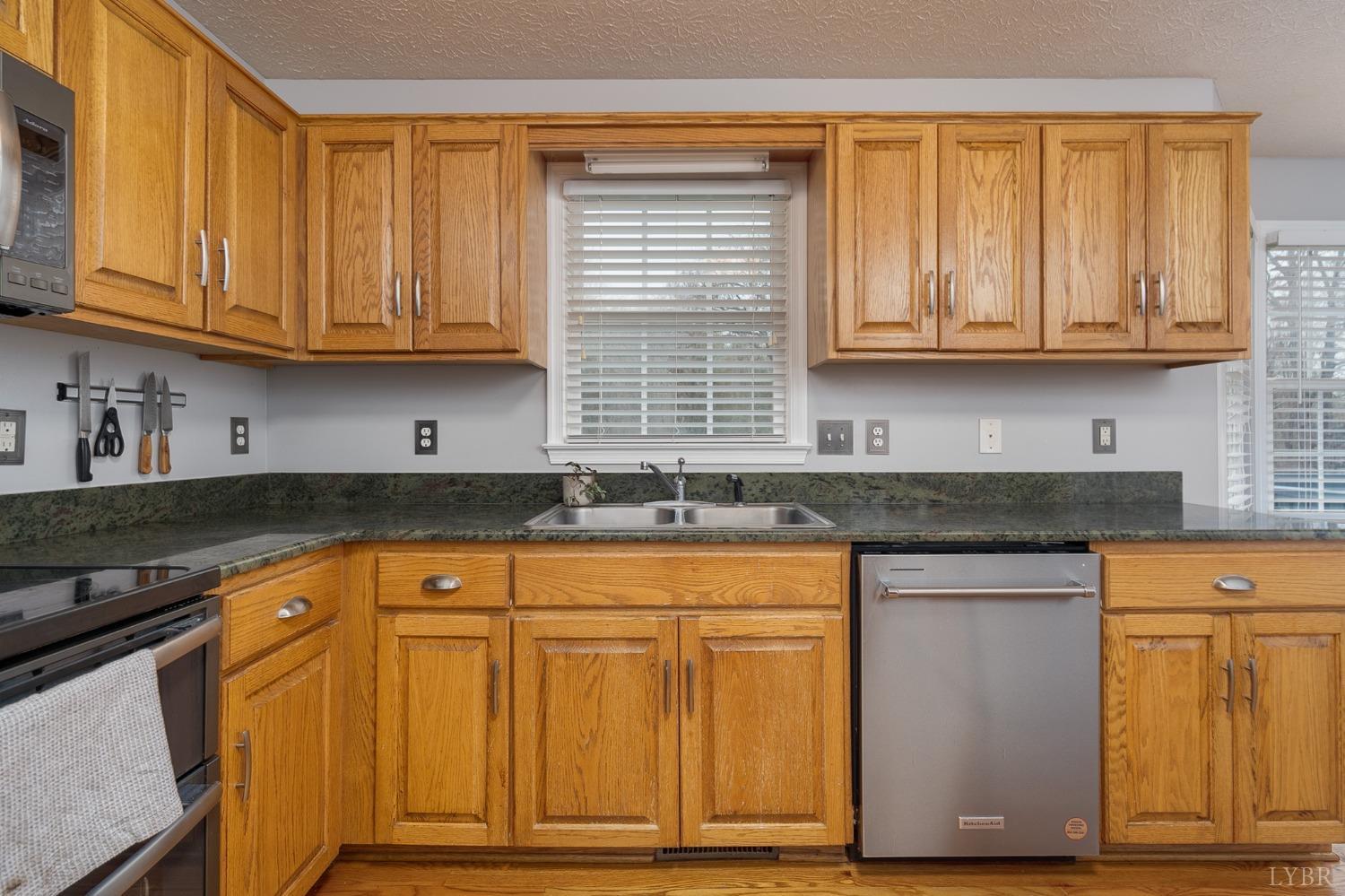 1498 Hooper Road Forest, VA 24551 - Photo 11 of 48 a kitchen with stainless steel appliances granite countertop wooden cabinets a sink and dishwasher with wooden floor
