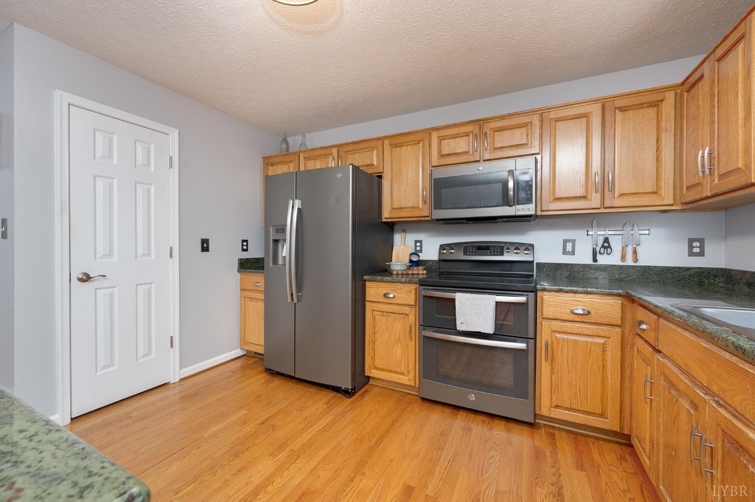 1498 Hooper Road Forest, VA 24551 - Photo 12 of 48 a kitchen with granite countertop wooden floors stainless steel appliances and a window