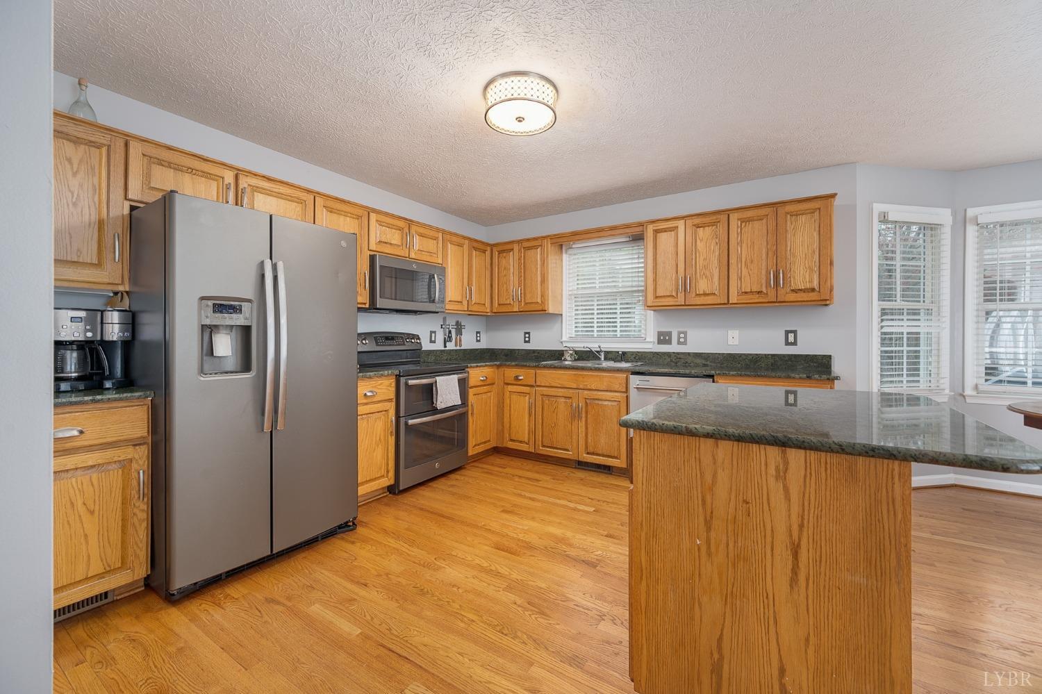 1498 Hooper Road Forest, VA 24551 - Photo 13 of 48 a kitchen with stainless steel appliances granite countertop a refrigerator and a stove top oven