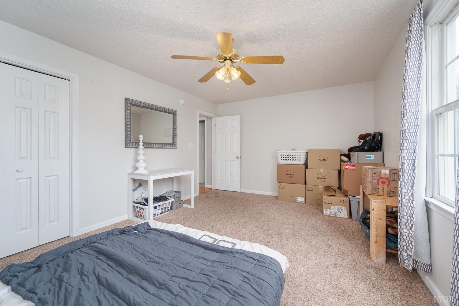 1498 Hooper Road Forest, VA 24551 - Photo 36 of 48 a bedroom with a bed and a chandelier