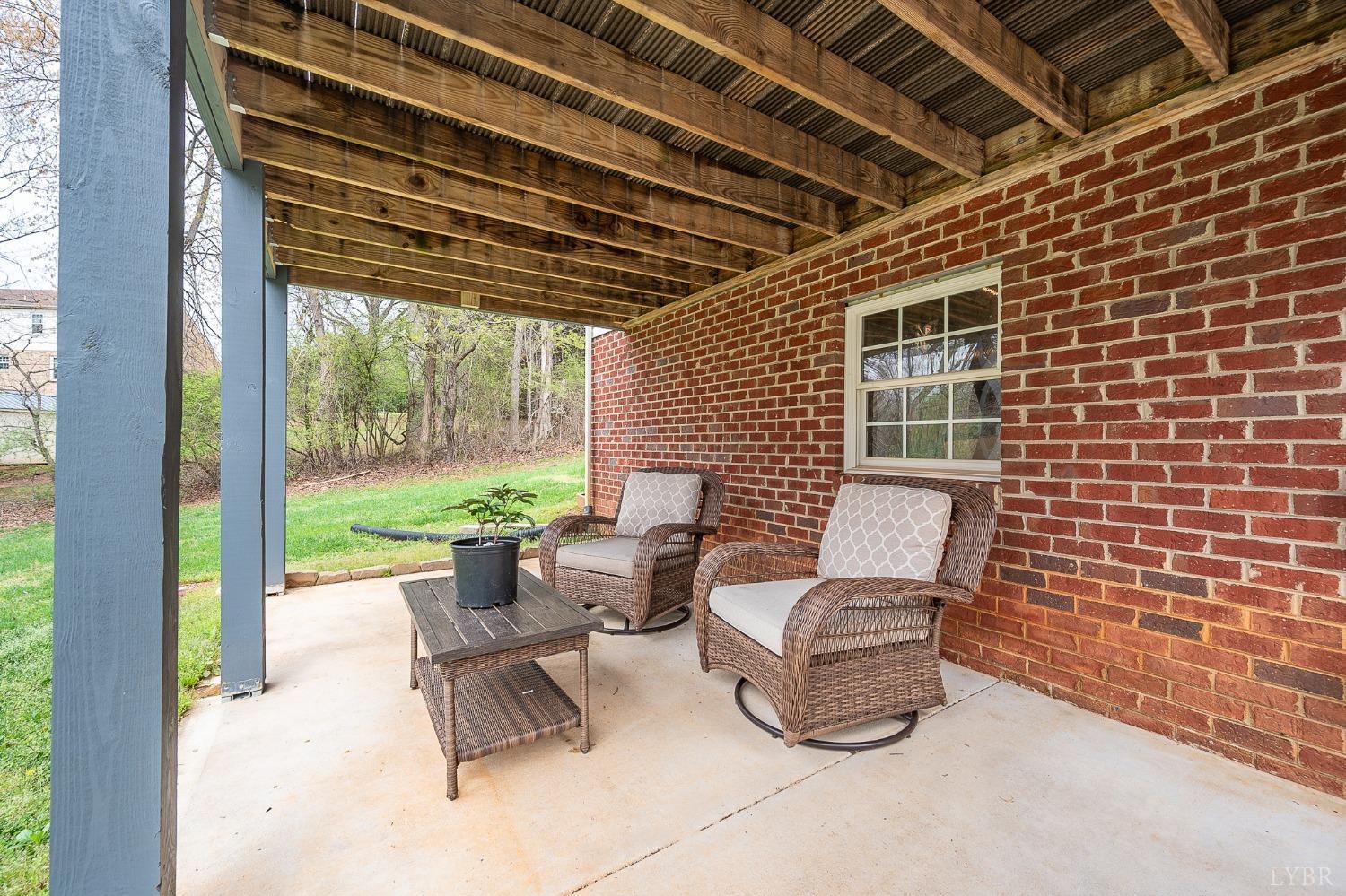 1498 Hooper Road Forest, VA 24551 - Photo 45 of 48 a view of a patio with chairs and floor to ceiling window and garden