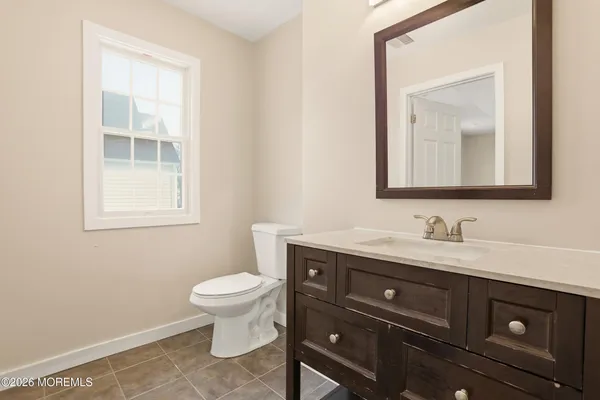 a bathroom with a toilet a sink a vanity and mirror