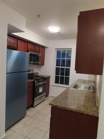 a kitchen with granite countertop a refrigerator and a sink