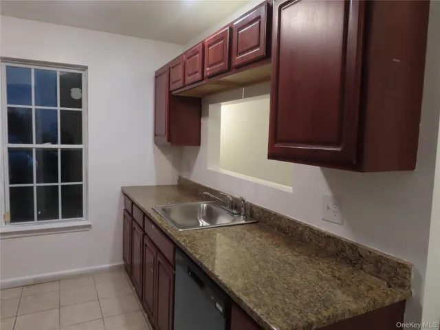 a kitchen with a sink a mirror and window