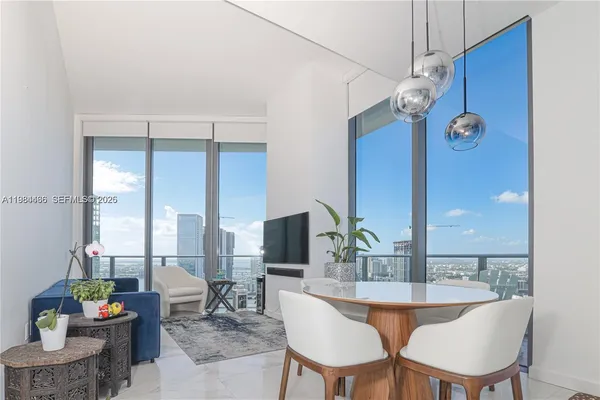 a dining room with furniture and a floor to ceiling window