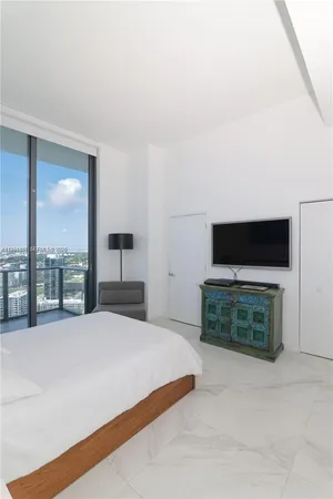 a bedroom with a bed and a television