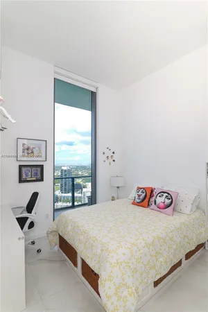 a bedroom with a bed and a large window