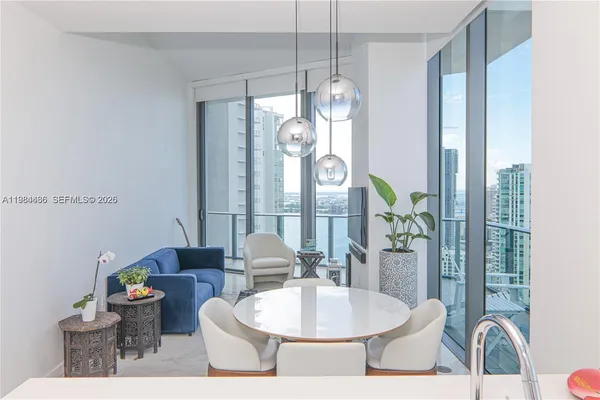 a dining room with furniture a chandelier and wooden floor