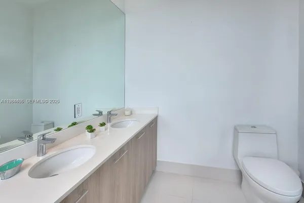 a bathroom with a sink vanity mirror and toilet