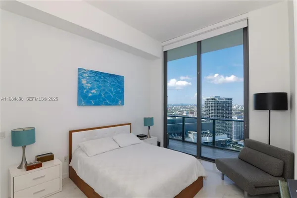 a bedroom with a bed and a view of kitchen