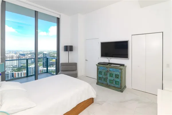 a bedroom with a bed and a flat screen tv