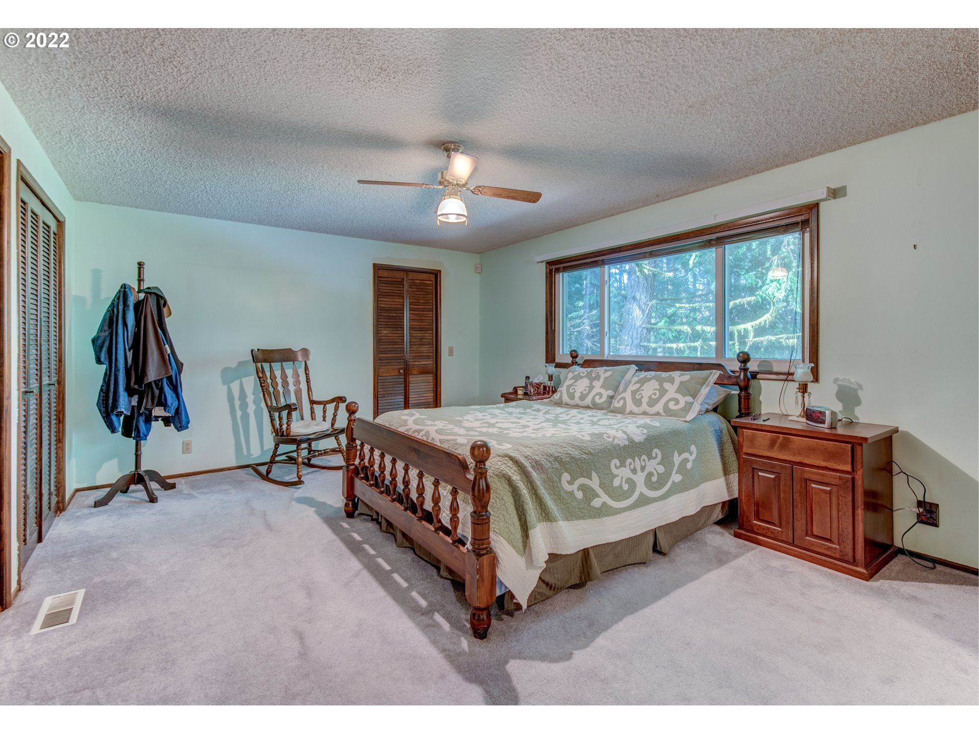 87125 Cedar Flat Road Springfield, OR 97478 - Photo 11 of 32 a spacious bedroom with a bed and a chandelier