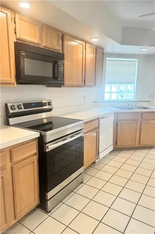 a kitchen with stainless steel appliances a stove microwave and sink