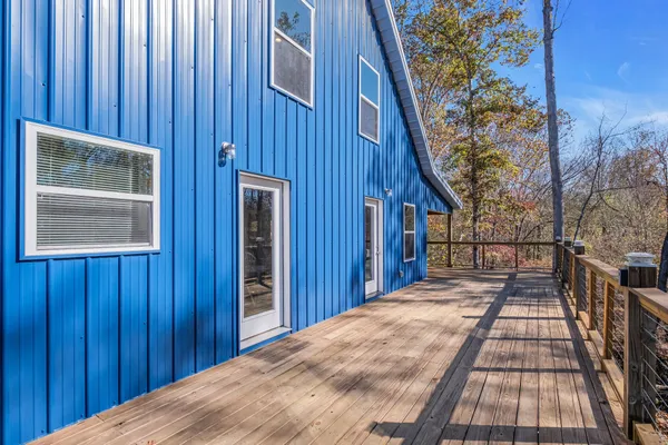 an empty room with windows fireplace and wooden floor
