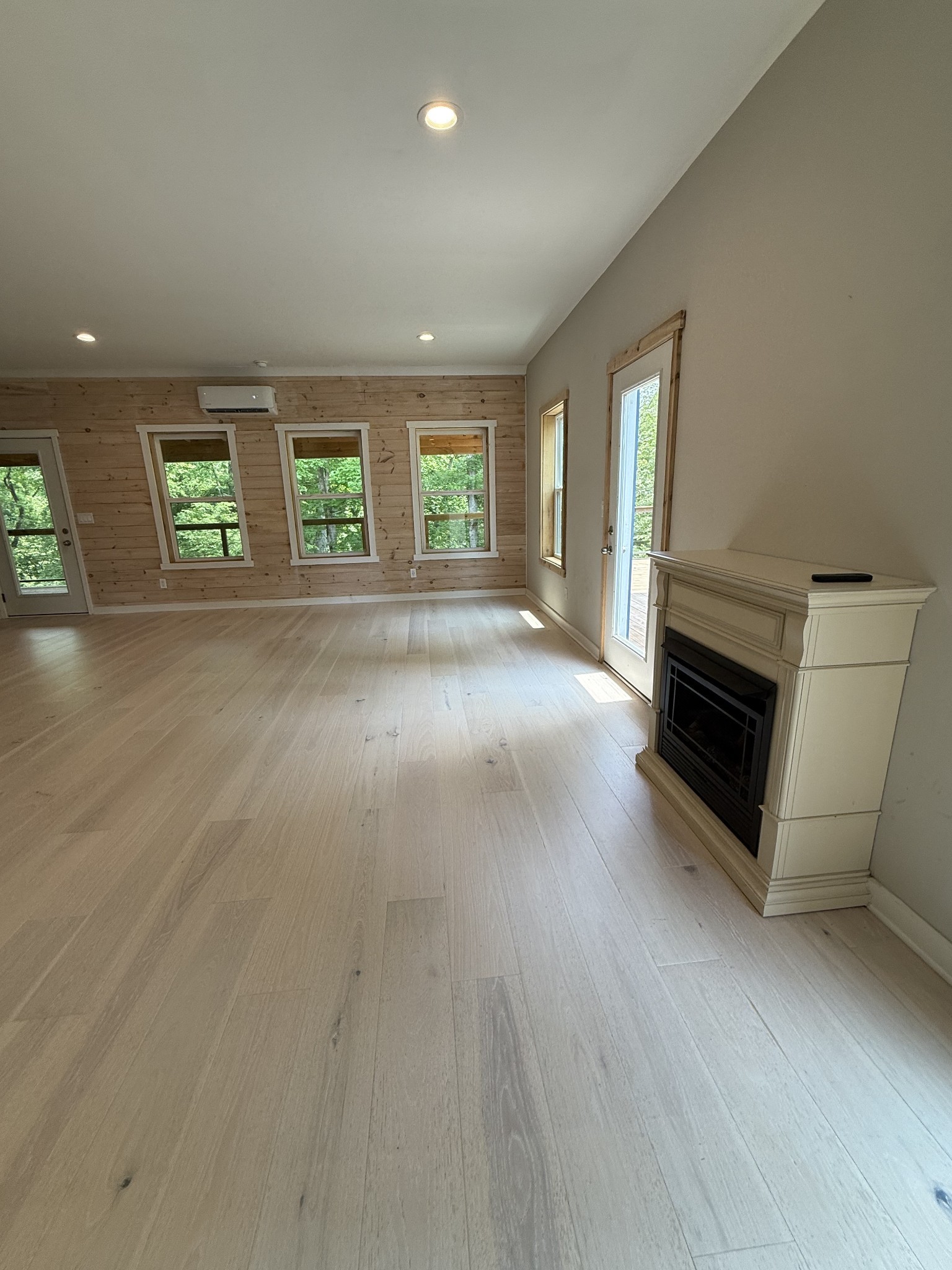 761 Metal Ford Road Hohenwald, TN 38462 - Photo 59 of 60 an empty room with windows fireplace and wooden floor