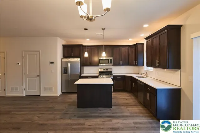 a kitchen with kitchen island a sink and a stove top oven
