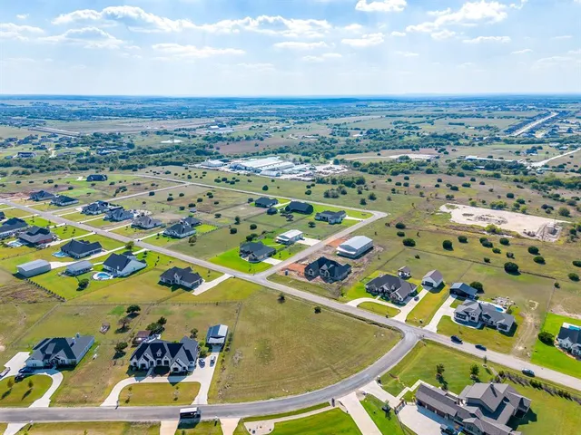 an aerial view of a residential houses with yard