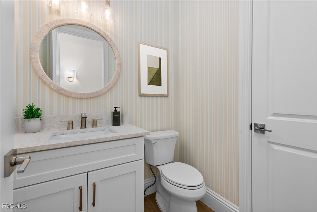 3383 Chestnut Grove Drive Alva, FL 33920 - Photo 20 of 33 a bathroom with a toilet a sink and a mirror