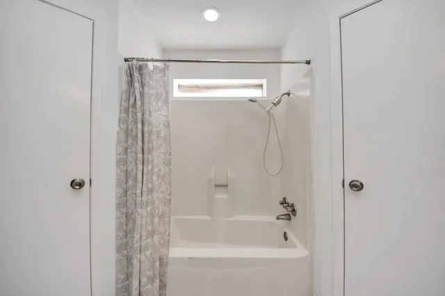 a bathroom with a shower and a bath tub