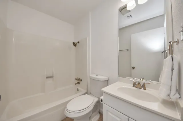 a bathroom with a sink toilet vanity and shower