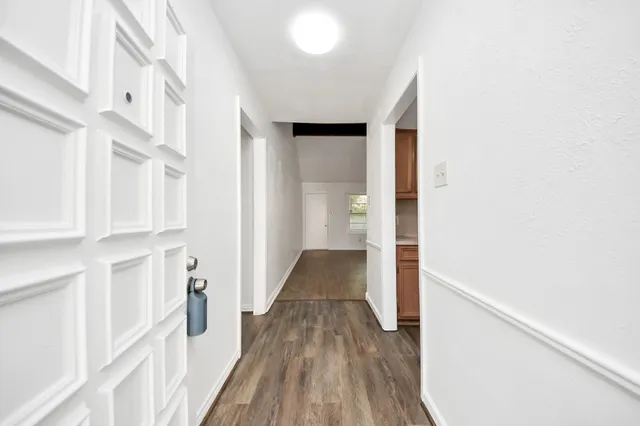 a view of a hallway with wooden floor and staircase