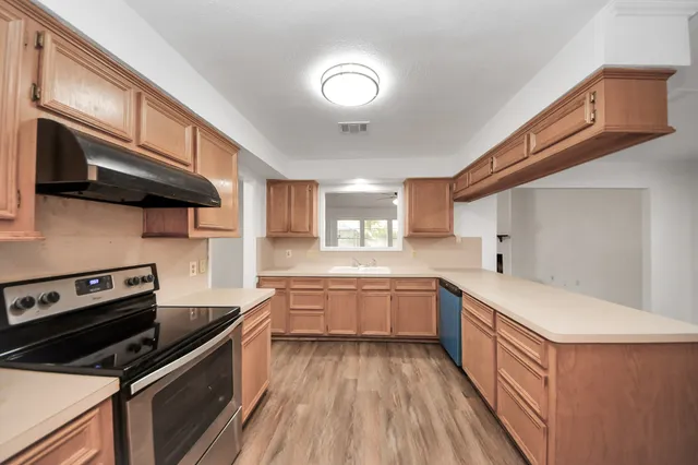 a kitchen with a sink stove and cabinets