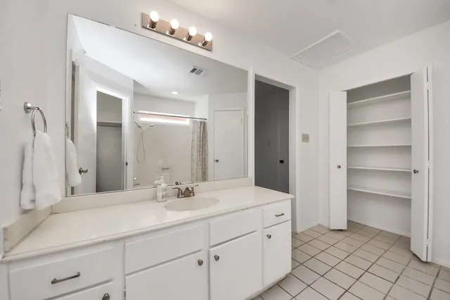 a bathroom with a sink vanity and a mirror