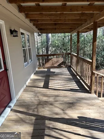a view of a porch with wooden floor and outdoor seating