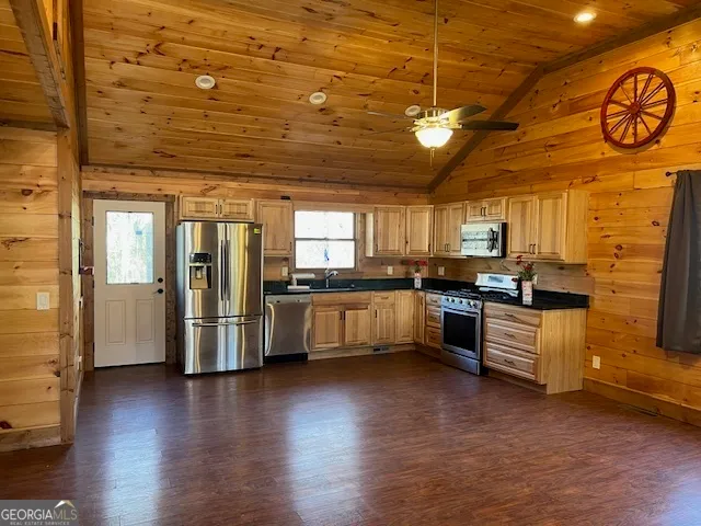 a kitchen with stainless steel appliances kitchen island granite countertop a refrigerator and a stove