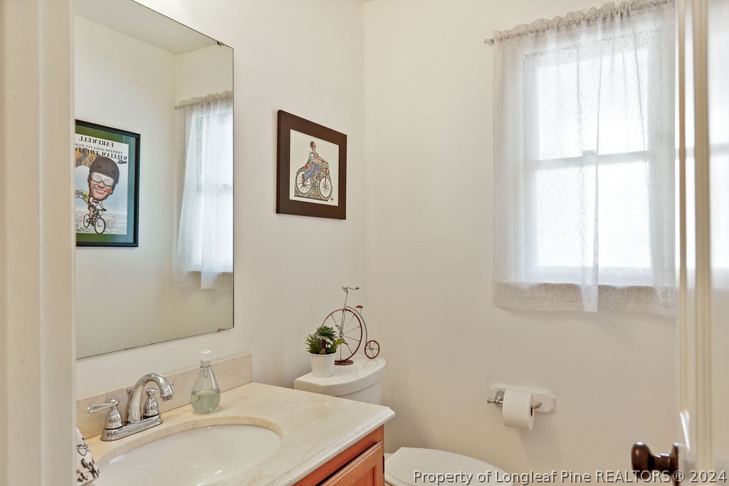 300 Shawcroft Road Fayetteville, NC 28311 - Photo 16 of 42 a bathroom with a granite countertop sink a toilet and a mirror