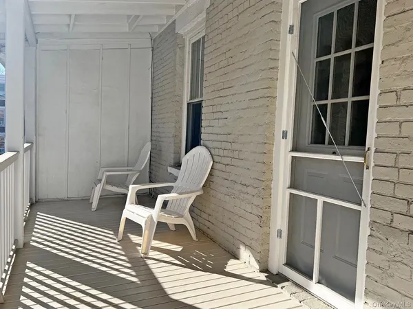 a patio with table and chairs and wooden floor