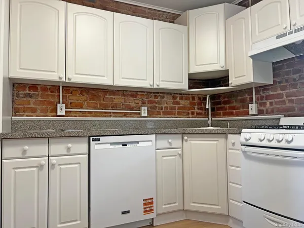 a kitchen with white cabinets and white appliances