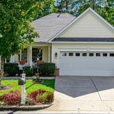 a view of house with garden and tall tress